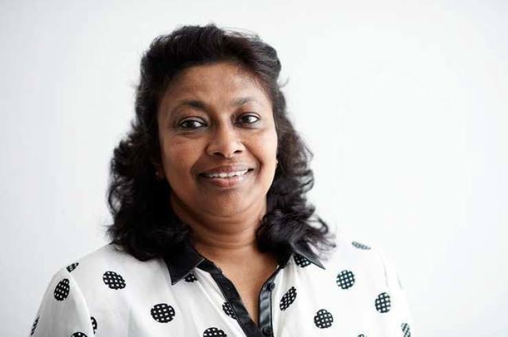 Notre responsable pays pour le Sri Lanka, Nayani Suriyarachchi. Elle a environ 60 ans, porte les cheveux noirs détachés et un chemisier blanc à pois noirs avec un col noir.