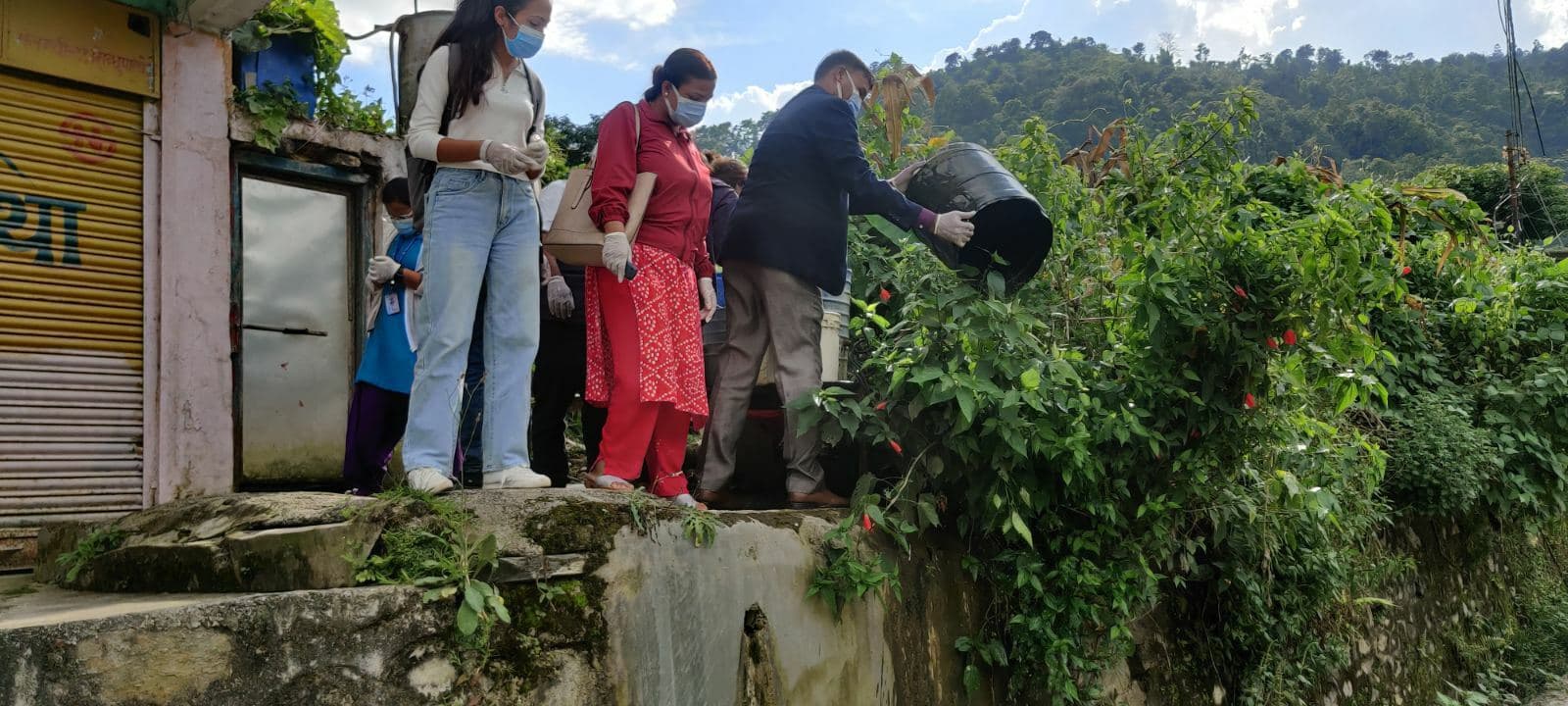 Différents acteurs vident un tonneau d'eau stagnante, car ils y soupçonnent la présence de larves.